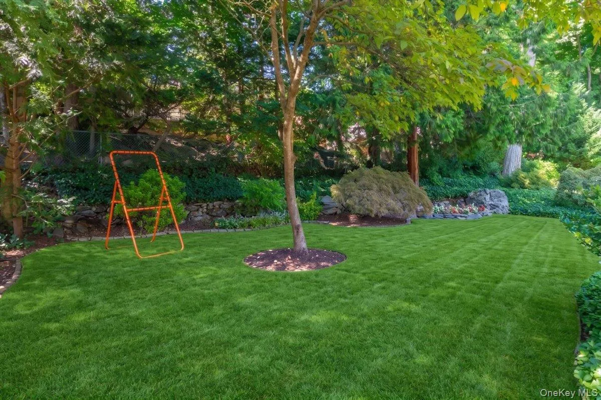 A beautifully landscaped, level backyard offers substantial usable lawn framed by mature specimen trees and established garden beds. A beautifully landscaped, level backyard offers substantial usable lawn framed by mature specimen trees and established garden beds.