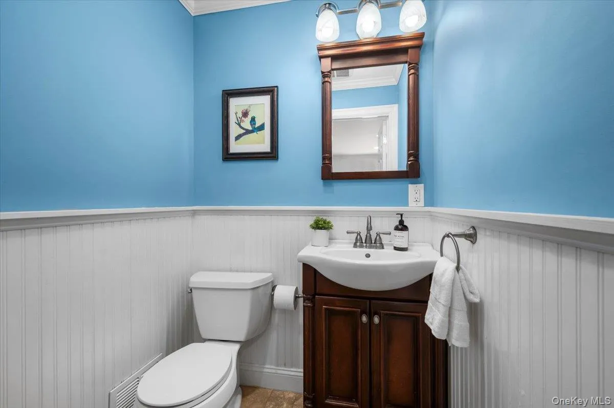 Conveniently located on the main level, the powder room combines beadboard wainscoting, a furniture-style vanity and classic crown molding. Conveniently located on the main level, the powder room combines beadboard wainscoting, a furniture-style vanity and classic crown molding.