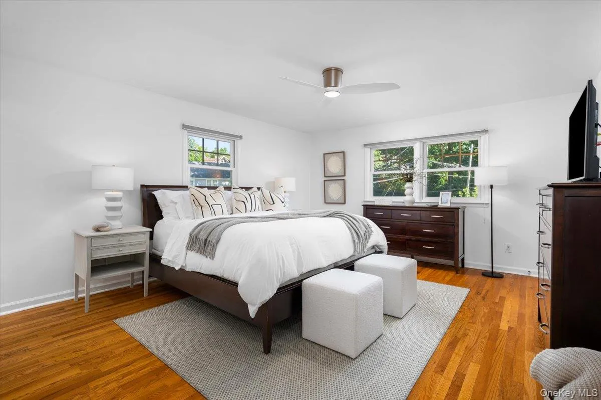 The serene primary bedroom offers generous proportions, hardwood floors, multiple windows and ample room for substantial furnishings. The serene primary bedroom offers generous proportions, hardwood floors, multiple windows and ample room for substantial furnishings.