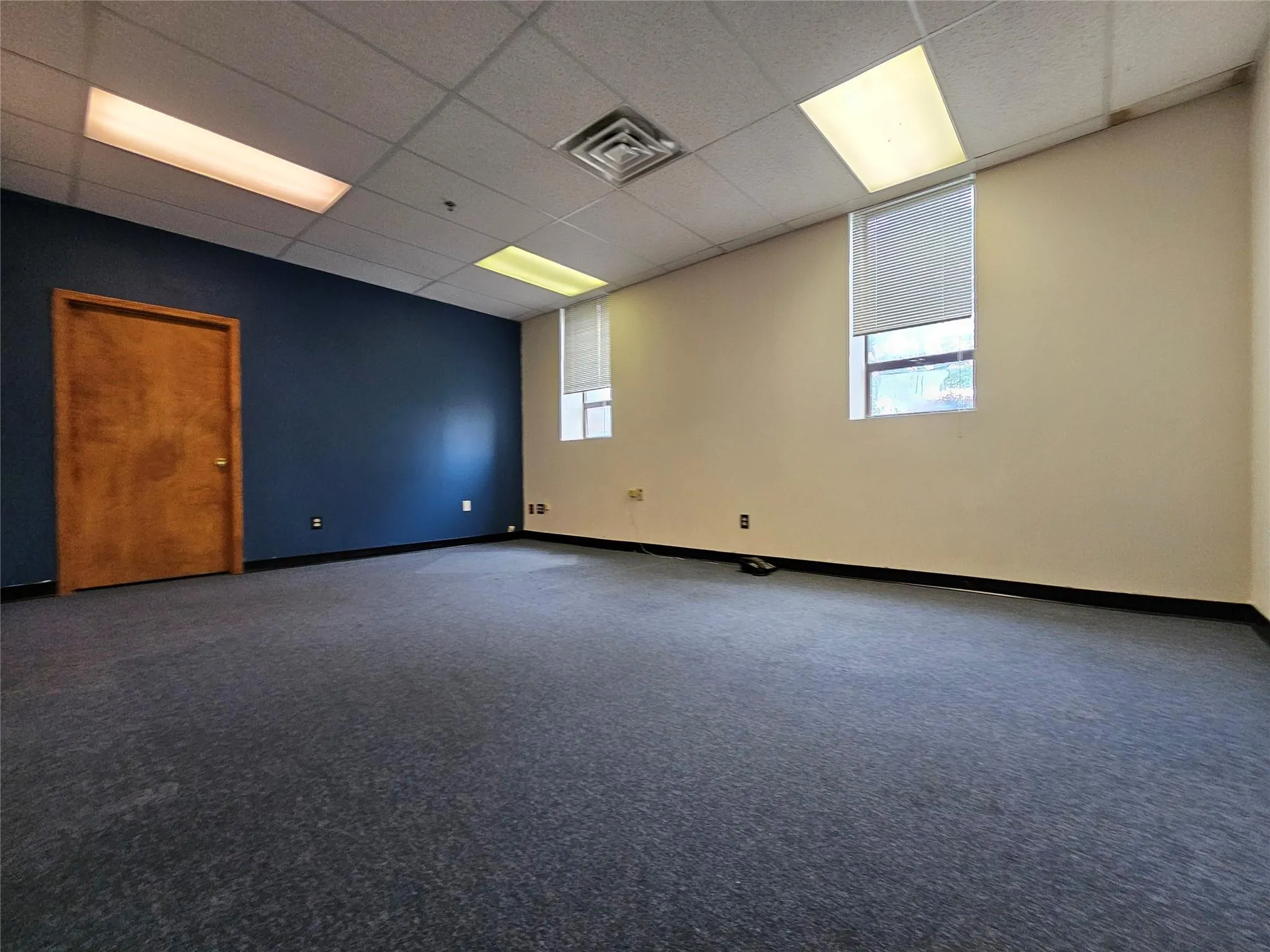 Spare room featuring plenty of natural light, a paneled ceiling, baseboards, and carpet flooring Spare room featuring plenty of natural light, a paneled ceiling, baseboards, and carpet flooring
