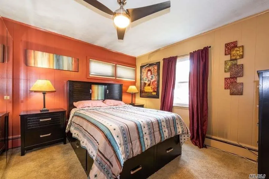 Bedroom featuring baseboard heating, carpet flooring, and ceiling fan Bedroom featuring baseboard heating, carpet flooring, and ceiling fan