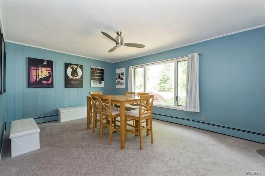 Dining area featuring ornamental molding, carpet flooring, ceiling fan, and a baseboard heating unit Dining area featuring ornamental molding, carpet flooring, ceiling fan, and a baseboard heating unit
