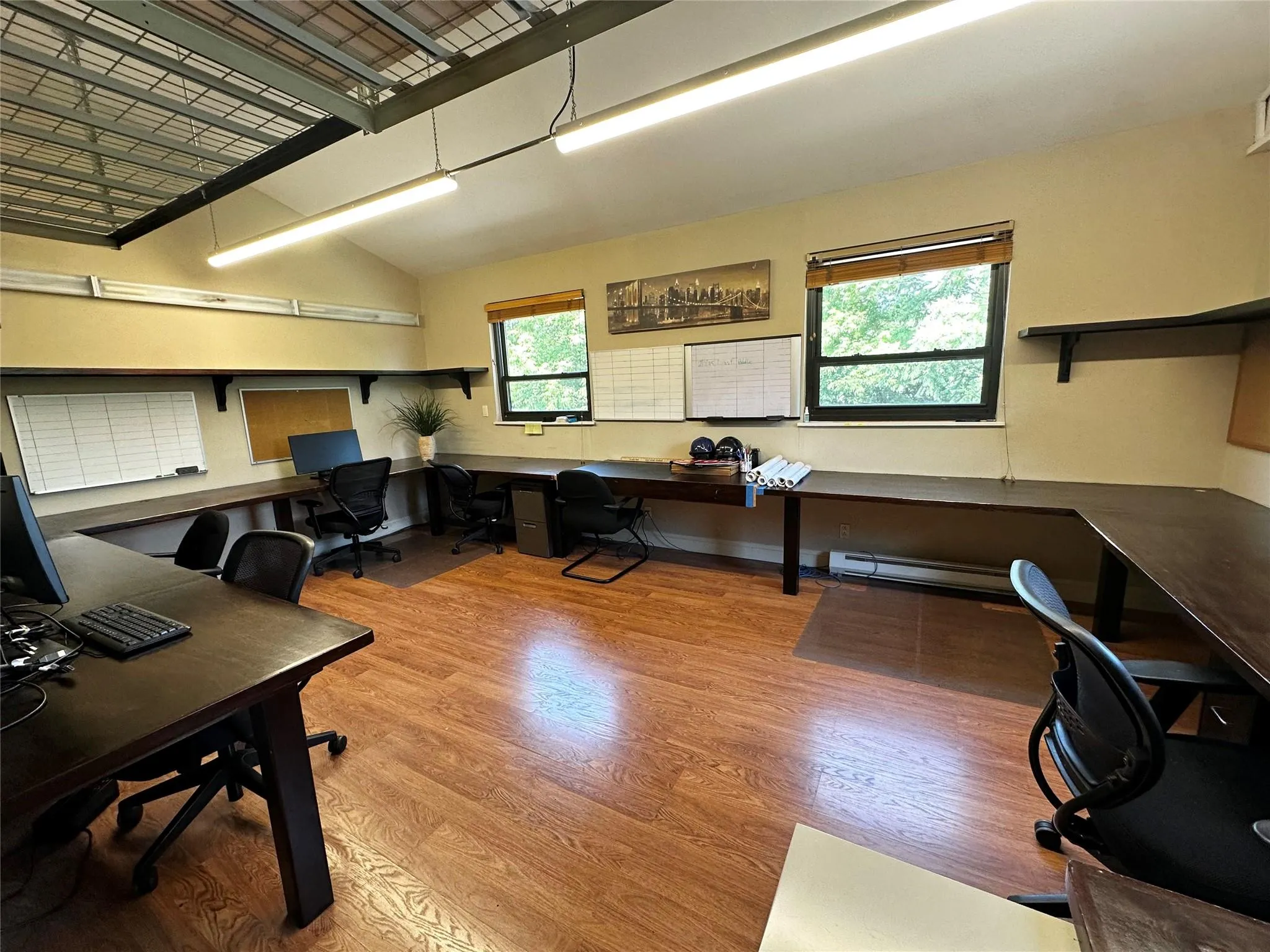 Home office with wood finished floors, a baseboard radiator, and built in desk Home office with wood finished floors, a baseboard radiator, and built in desk
