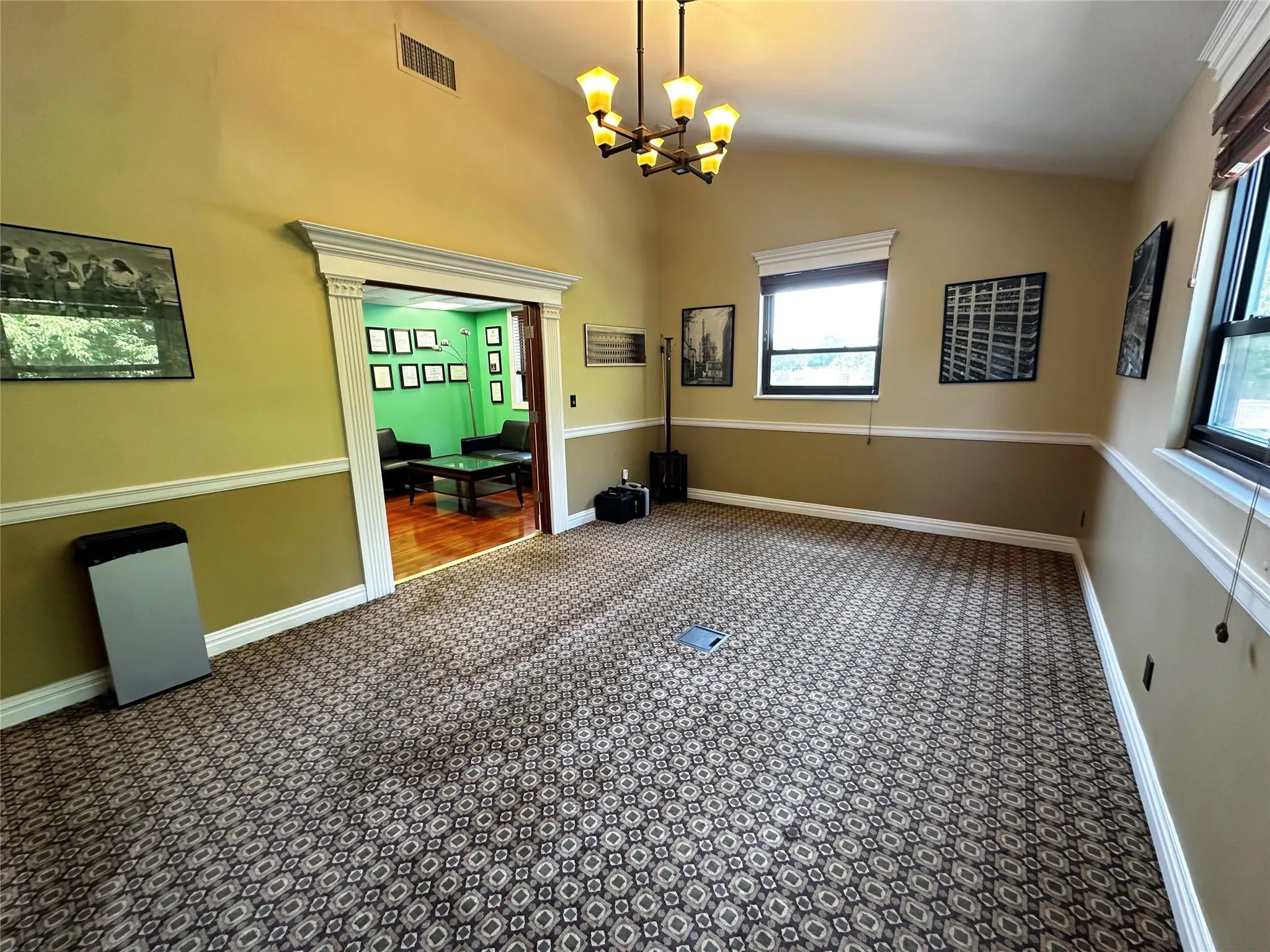 Unfurnished dining area featuring carpet flooring, a chandelier, plenty of natural light, and vaulted ceiling Unfurnished dining area featuring carpet flooring, a chandelier, plenty of natural light, and vaulted ceiling