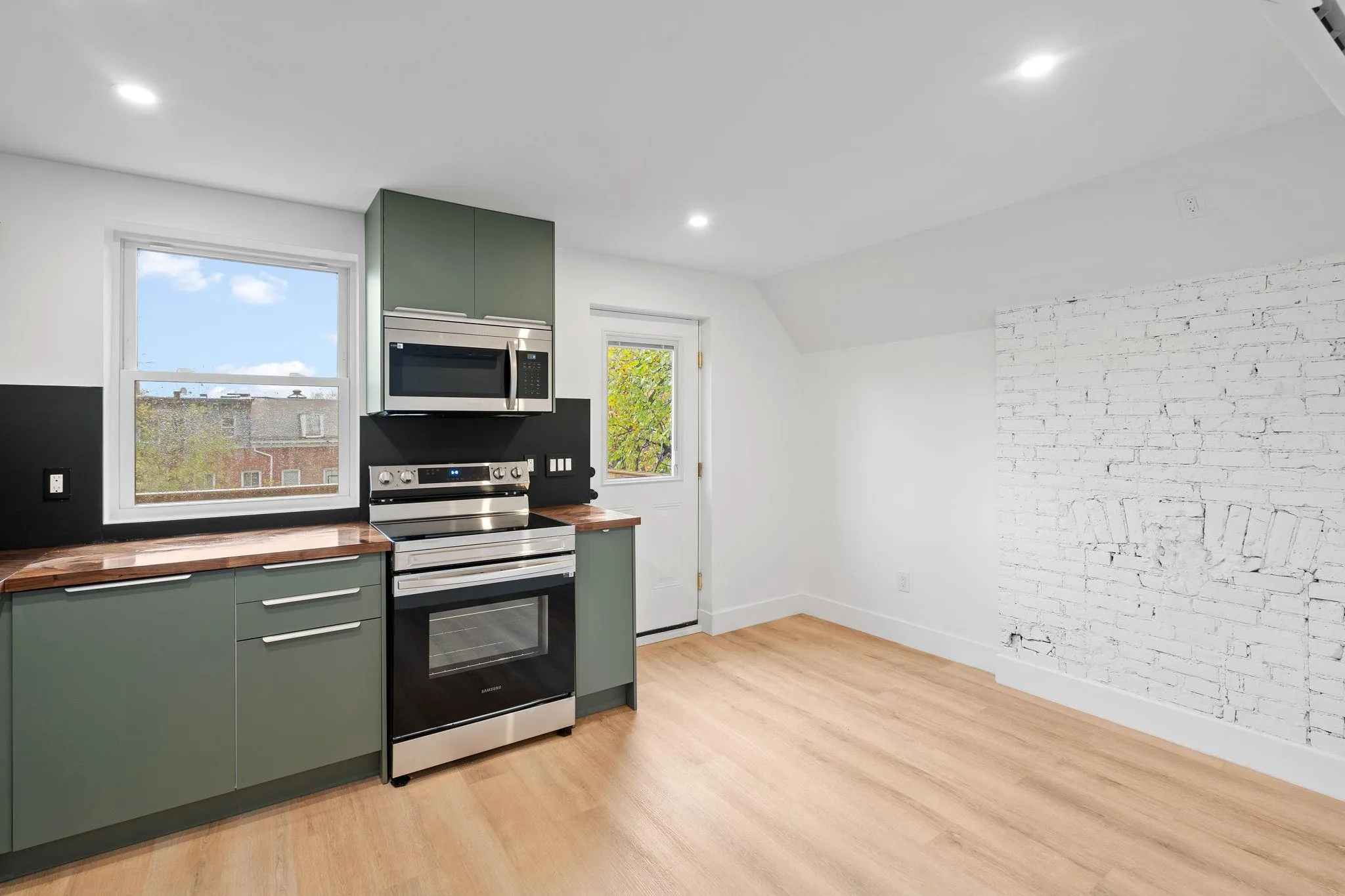 Kitchen featuring butcher block countertops, green cabinets, and appliances with stainless steel finishes Kitchen featuring butcher block countertops, green cabinets, and appliances with stainless steel finishes