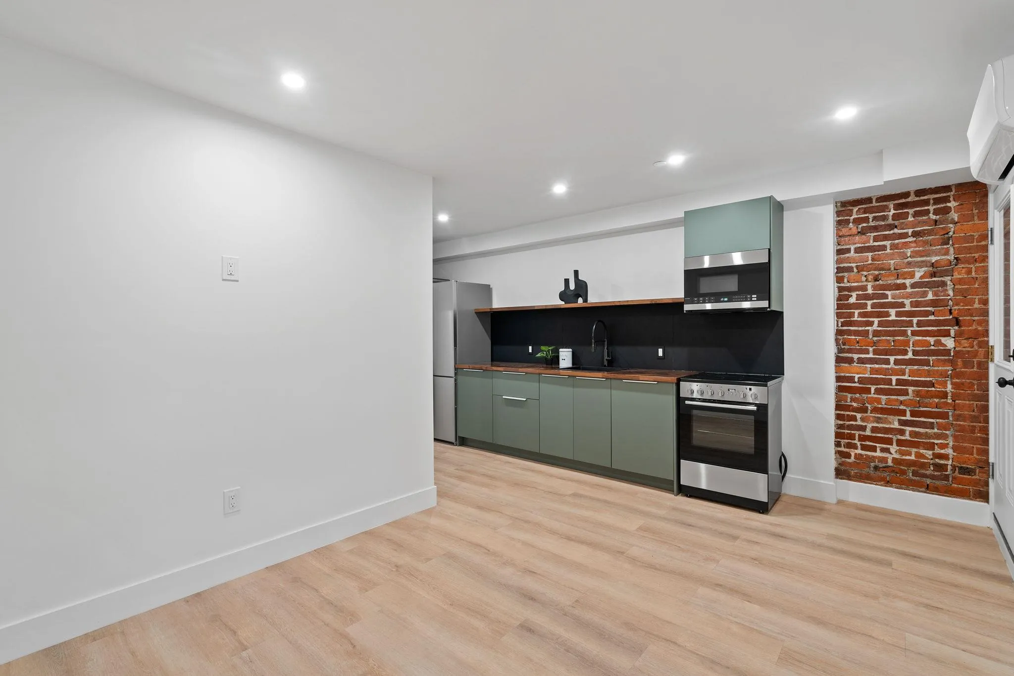 Kitchen with stainless steel appliances, green cabinetry, light hardwood / wood-style floors, and sink Kitchen with stainless steel appliances, green cabinetry, light hardwood / wood-style floors, and sink