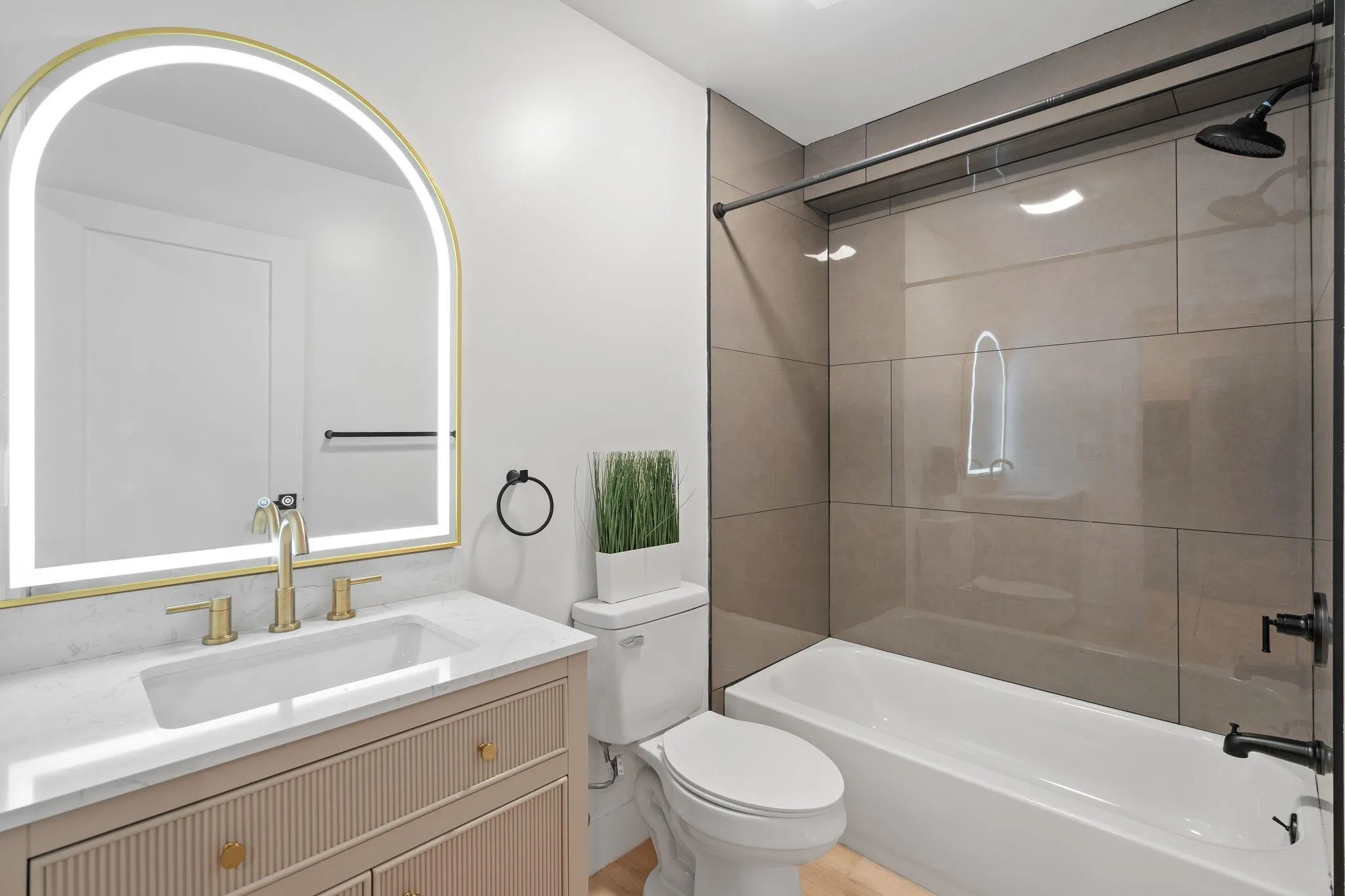 Full bathroom with hardwood / wood-style floors, vanity, toilet, and tiled shower / bath Full bathroom with hardwood / wood-style floors, vanity, toilet, and tiled shower / bath