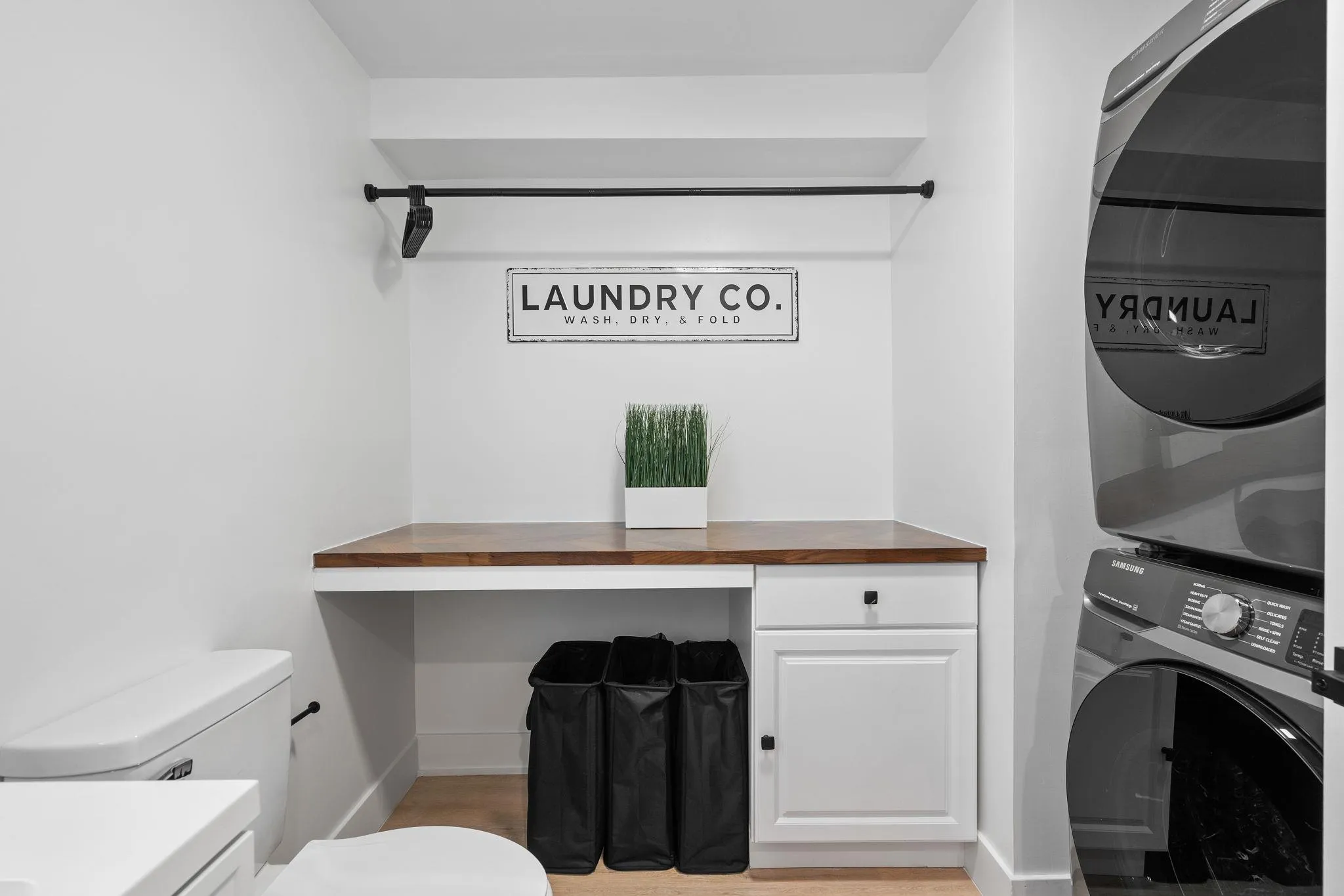 Washroom featuring cabinets and stacked washing maching and dryer Washroom featuring cabinets and stacked washing maching and dryer