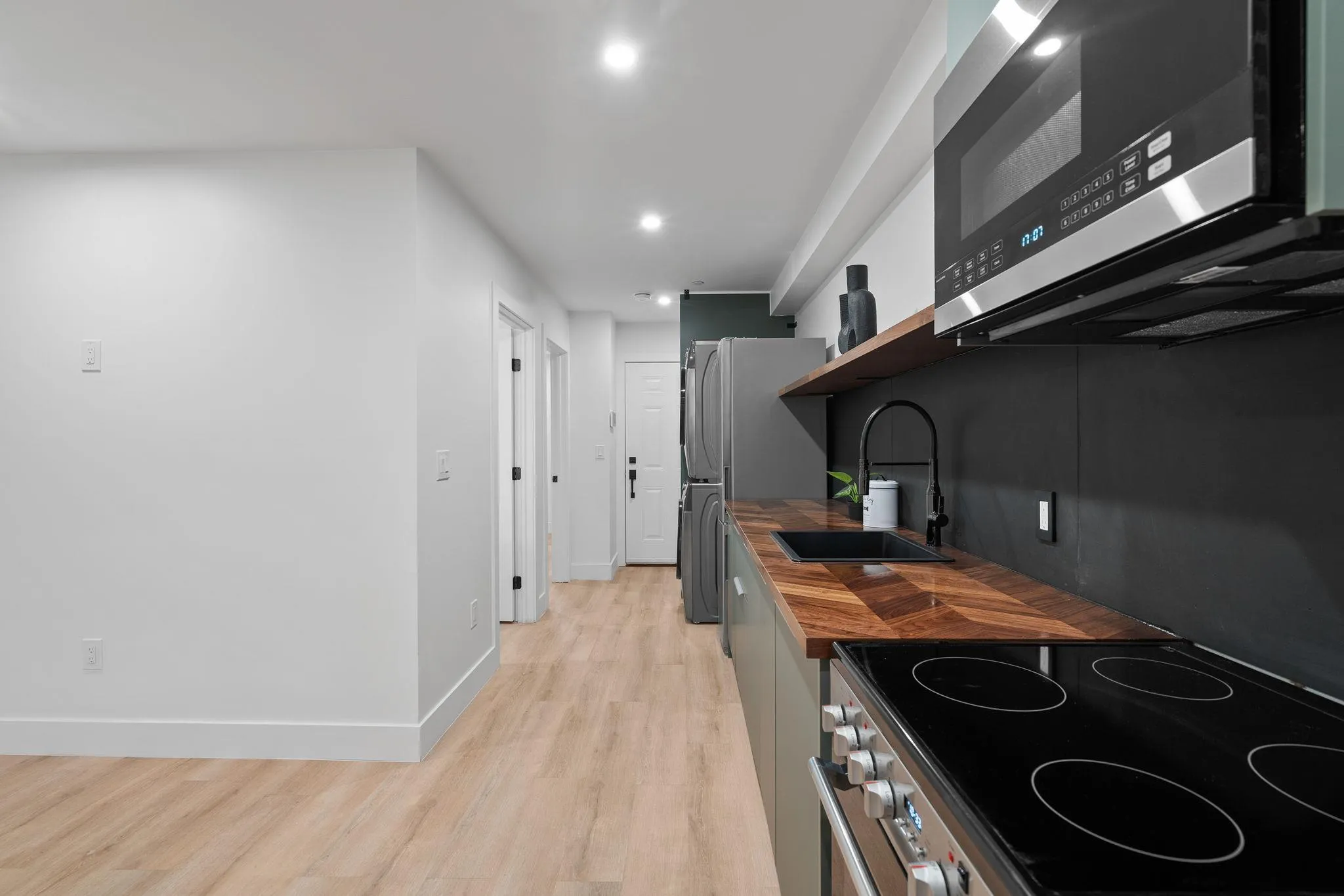 Kitchen featuring sink, stainless steel appliances, and light hardwood / wood-style flooring Kitchen featuring sink, stainless steel appliances, and light hardwood / wood-style flooring