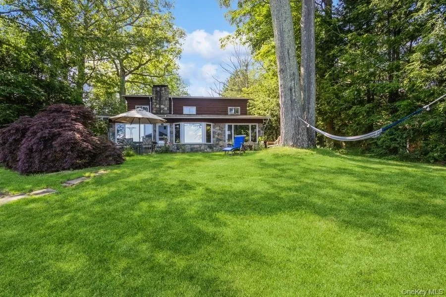 Lake view of property featuring the front lawn facing the lake Lake view of property featuring the front lawn facing the lake