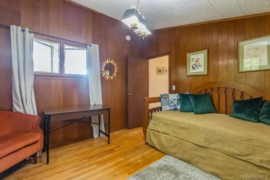Bedroom with wood finished floors and wood walls Bedroom with wood finished floors and wood walls