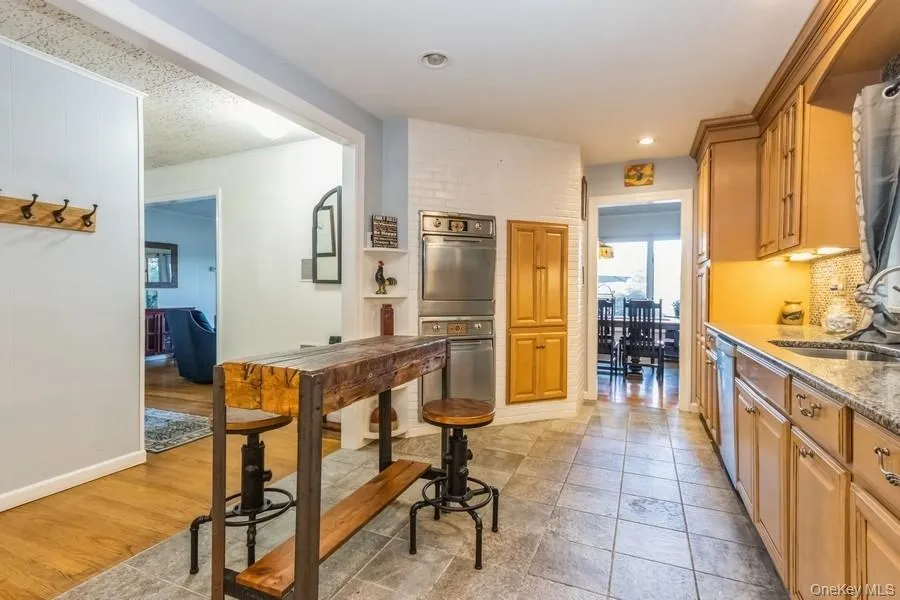 Kitchen featuring stainless steel appliances, tasteful backsplash, recessed lighting, and light stone countertops Kitchen featuring stainless steel appliances, tasteful backsplash, recessed lighting, and light stone countertops