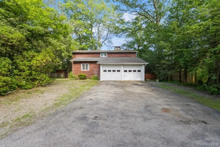 Chalet / cabin featuring asphalt driveway and a chimney Chalet / cabin featuring asphalt driveway and a chimney