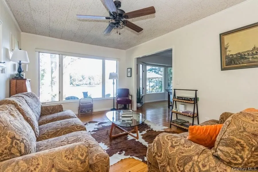 Living area featuring wood finished floors, and  ceiling fan Living area featuring wood finished floors, and  ceiling fan