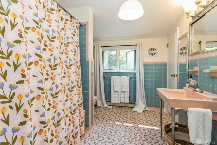 Full bathroom with tile walls, shower,  and tile patterned floors Full bathroom with tile walls, shower,  and tile patterned floors