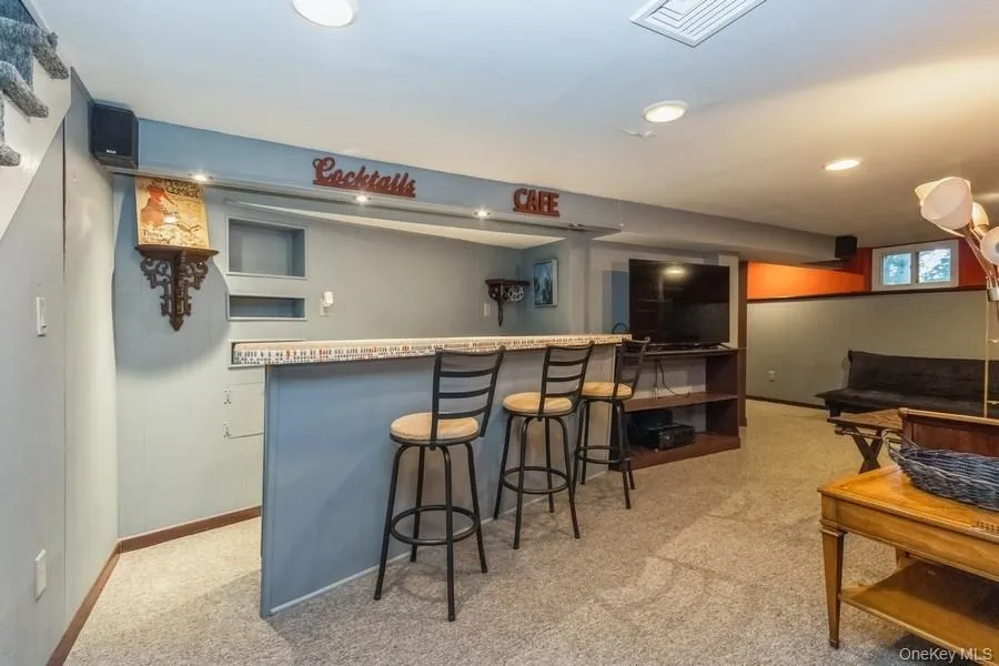 Kitchen featuring carpet flooring, a breakfast bar, and recessed lighting Kitchen featuring carpet flooring, a breakfast bar, and recessed lighting