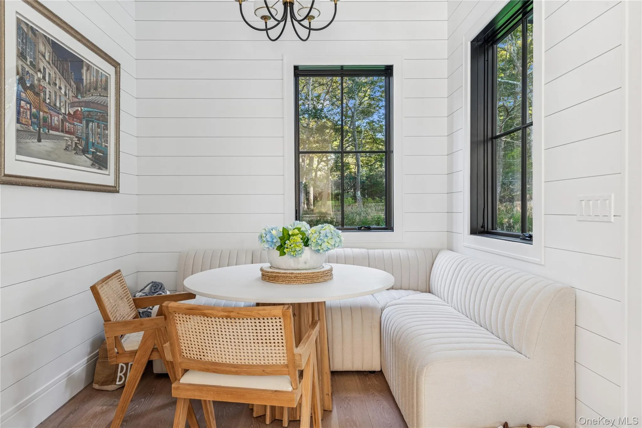 Dining room with plenty of natural light, wood finished floors, wood walls, breakfast area, and a chandelier Dining room with plenty of natural light, wood finished floors, wood walls, breakfast area, and a chandelier