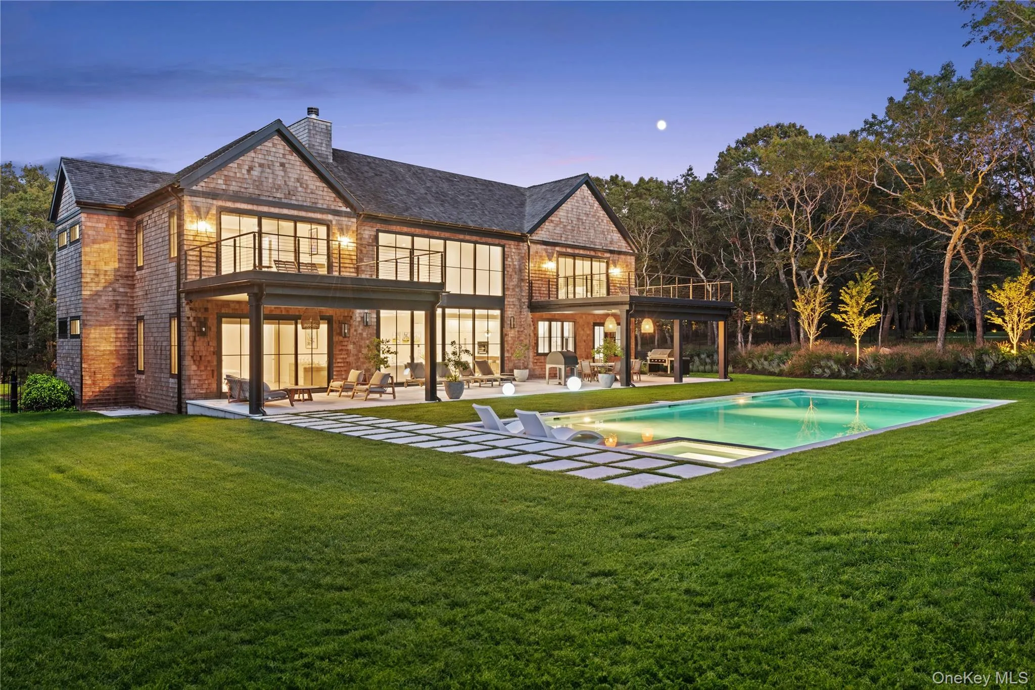 Rear view of property with a balcony, a patio, a yard, brick siding, and a chimney Rear view of property with a balcony, a patio, a yard, brick siding, and a chimney