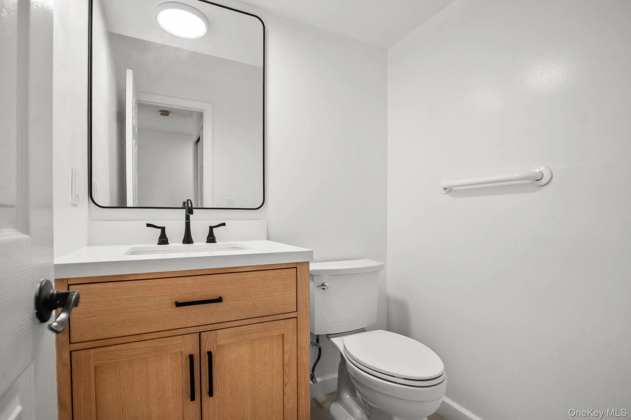 Crisp white walls and modern finishes give this refreshed half bath a clean, polished look. Crisp white walls and modern finishes give this refreshed half bath a clean, polished look.
