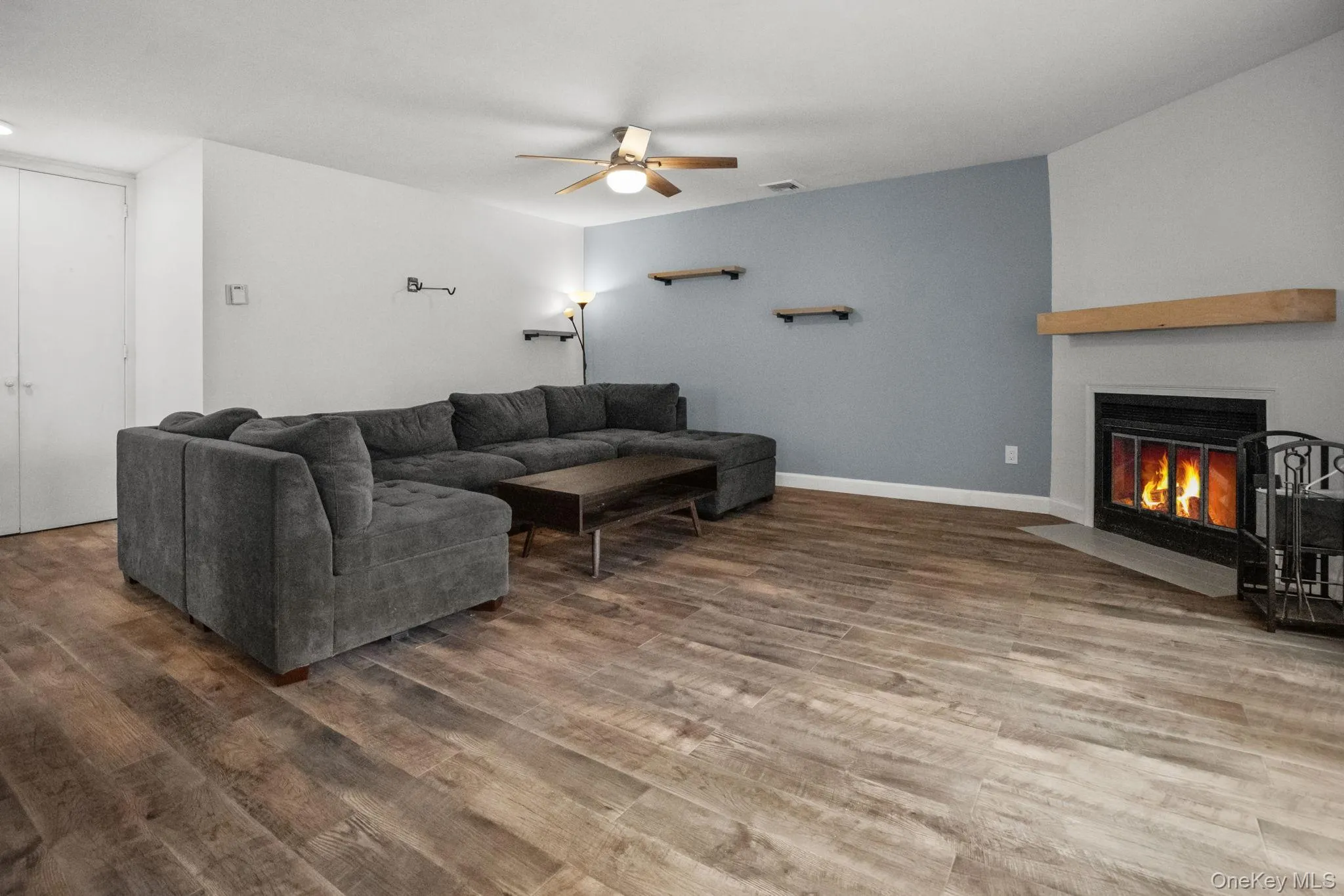The inviting living room features a wood-burning fireplace, new floors, and a modern ceiling fan for year-round comfort. The inviting living room features a wood-burning fireplace, new floors, and a modern ceiling fan for year-round comfort.