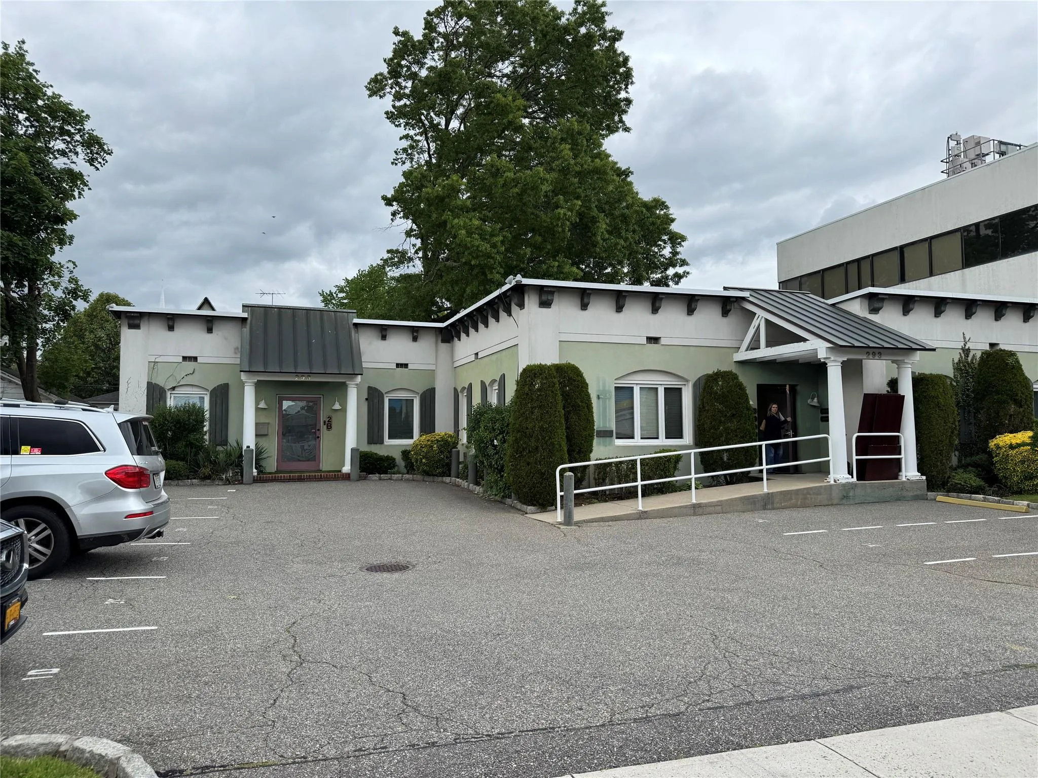 View of front of home featuring a standing seam roof, uncovered parking, a metal roof, and stucco siding View of front of home featuring a standing seam roof, uncovered parking, a metal roof, and stucco siding