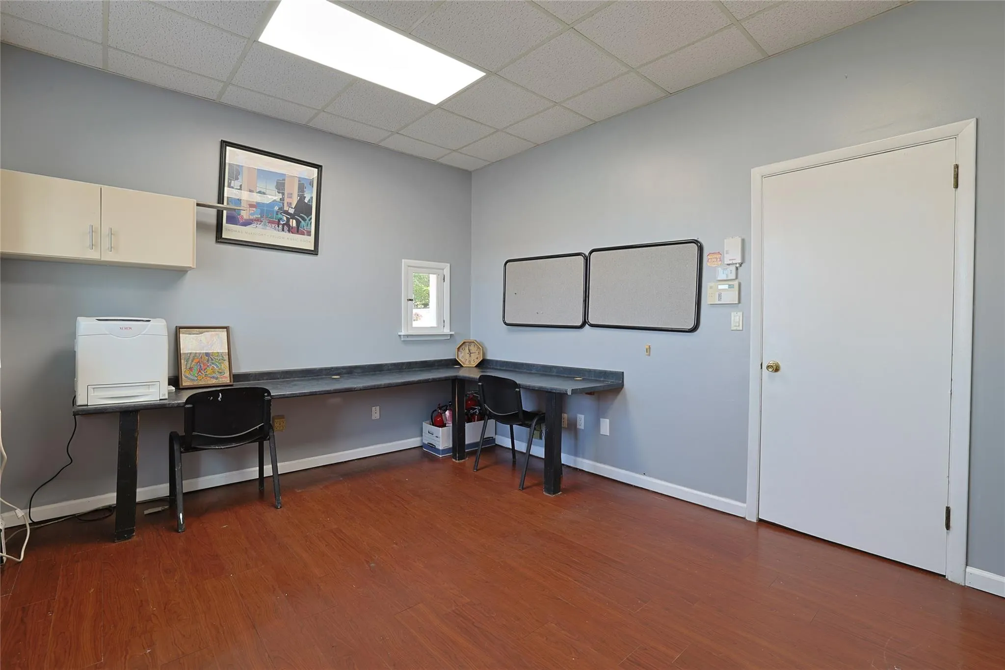 Office space with wood finished floors and a drop ceiling Office space with wood finished floors and a drop ceiling