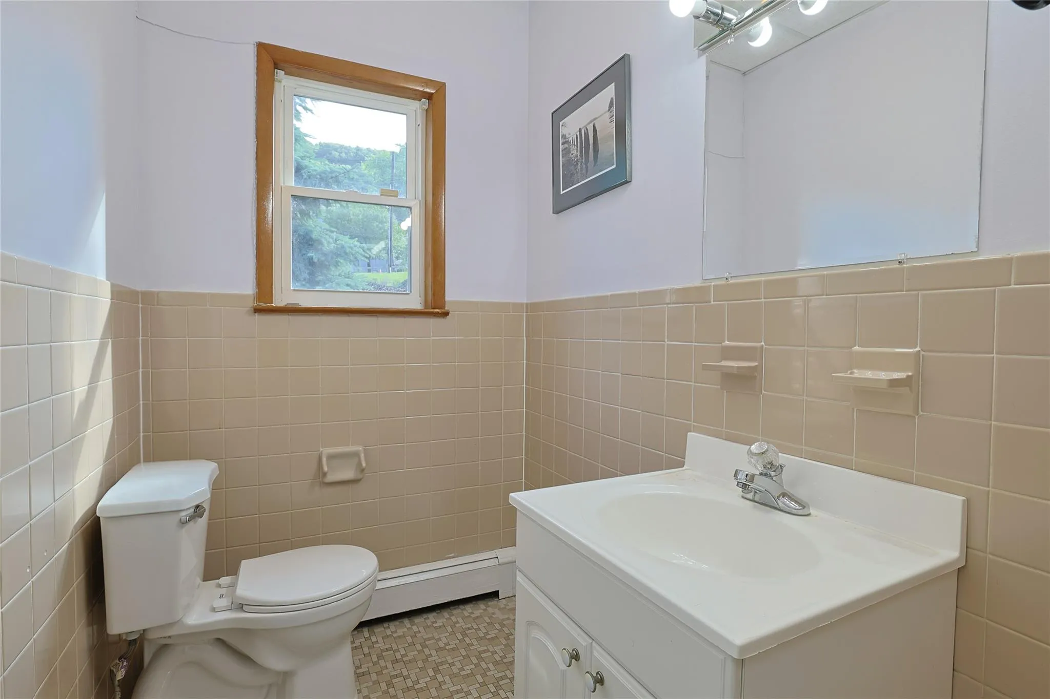 Bathroom with tile walls, baseboard heating, vanity, and wainscoting Bathroom with tile walls, baseboard heating, vanity, and wainscoting