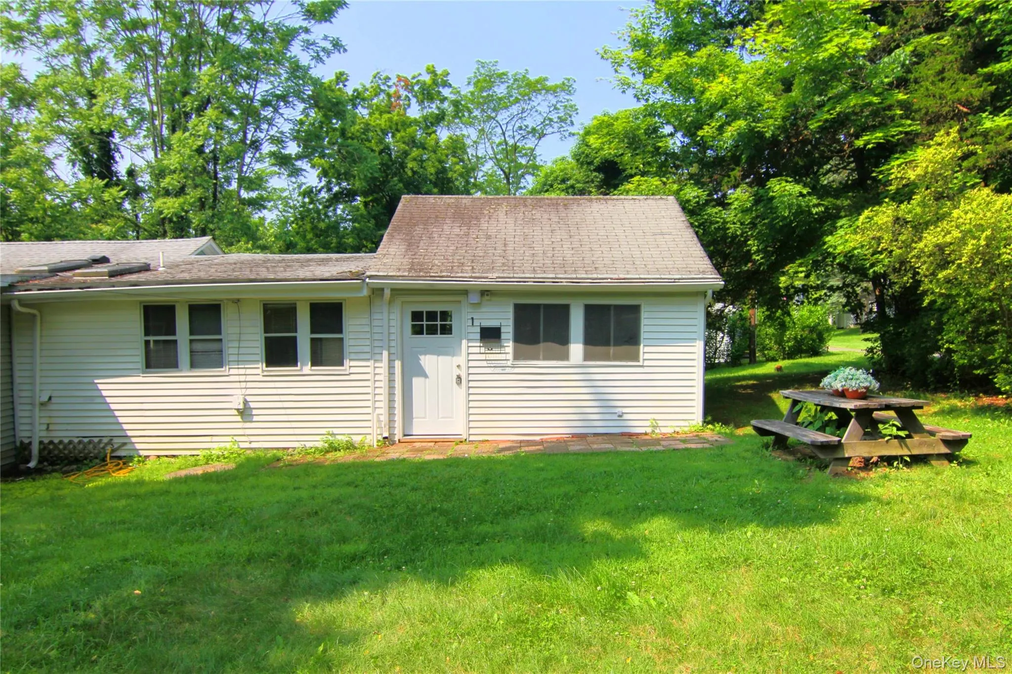 View of front of home with a front yard and a shingled roof View of front of home with a front yard and a shingled roof