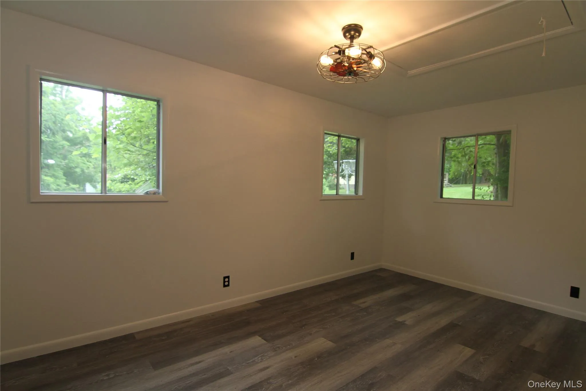 Empty room featuring attic access and dark wood-style flooring Empty room featuring attic access and dark wood-style flooring