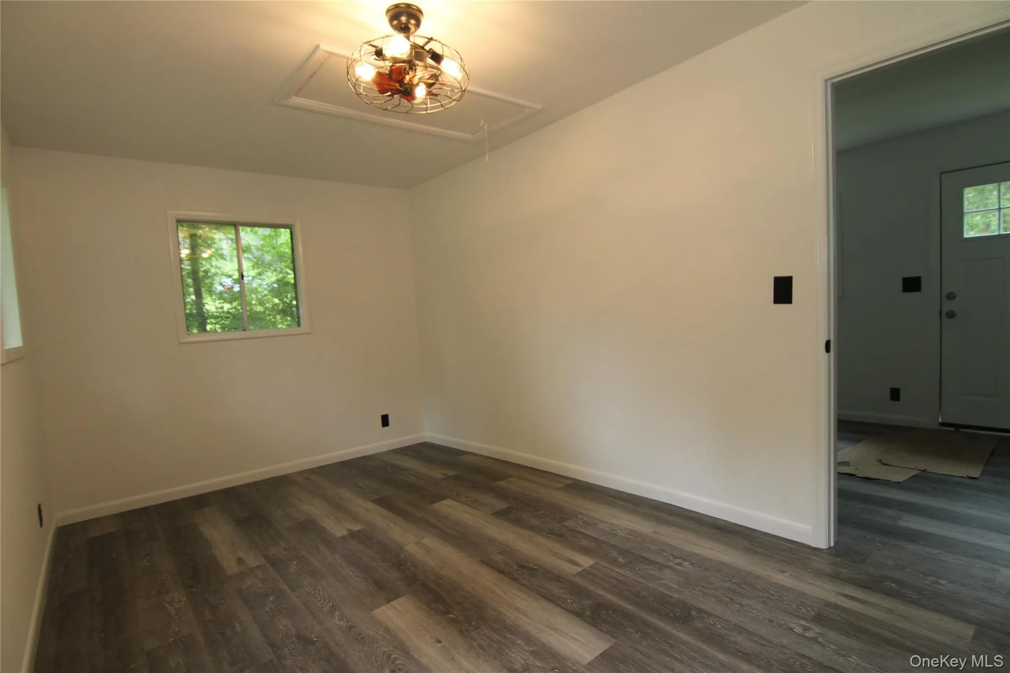 Unfurnished room with attic access and dark wood-style floors Unfurnished room with attic access and dark wood-style floors