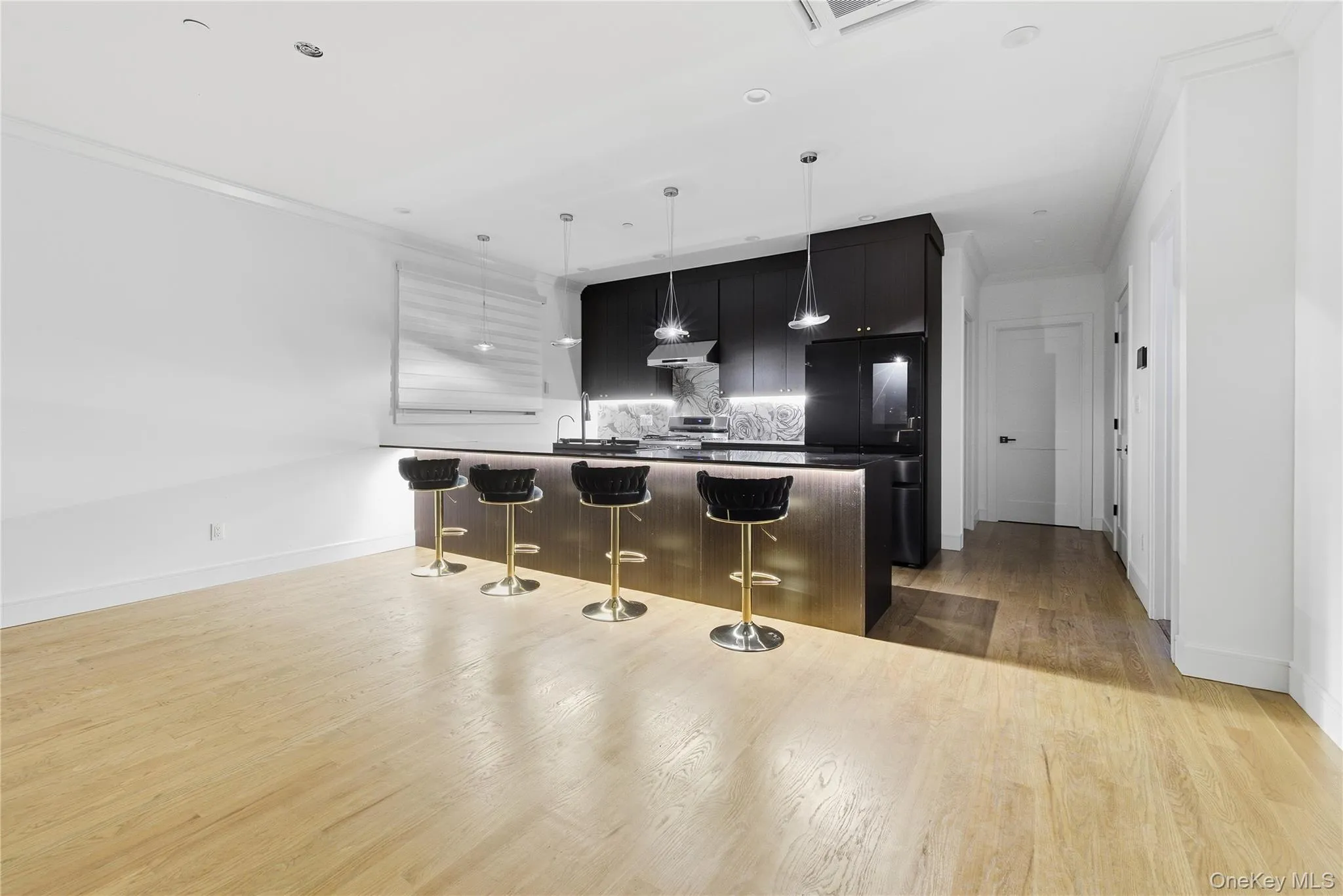 Kitchen featuring dark cabinetry, dark countertops, a breakfast bar area, tasteful backsplash, and freestanding refrigerator Kitchen featuring dark cabinetry, dark countertops, a breakfast bar area, tasteful backsplash, and freestanding refrigerator