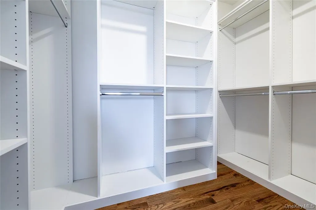 Walk in closet with wood flooring Walk in closet with wood flooring
