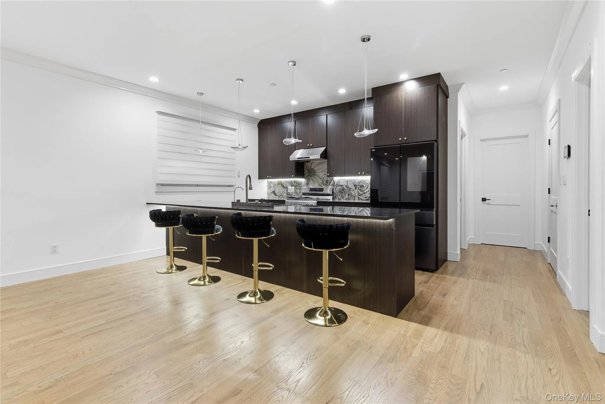 Kitchen with crown molding, a breakfast bar area, dark brown cabinets, tasteful backsplash, and smart refrigerator Kitchen with crown molding, a breakfast bar area, dark brown cabinets, tasteful backsplash, and smart refrigerator