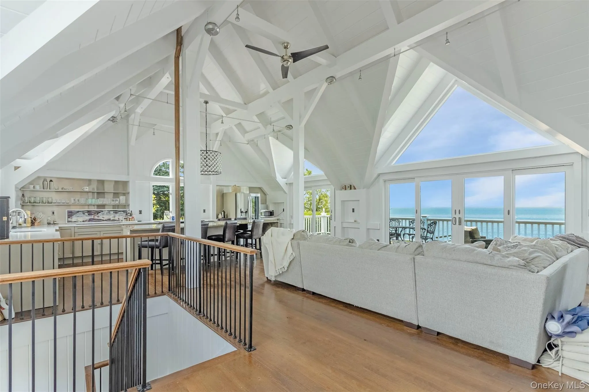 Living area with ceiling fan, a water view, beamed ceiling, plenty of natural light, and high vaulted ceiling Living area with ceiling fan, a water view, beamed ceiling, plenty of natural light, and high vaulted ceiling