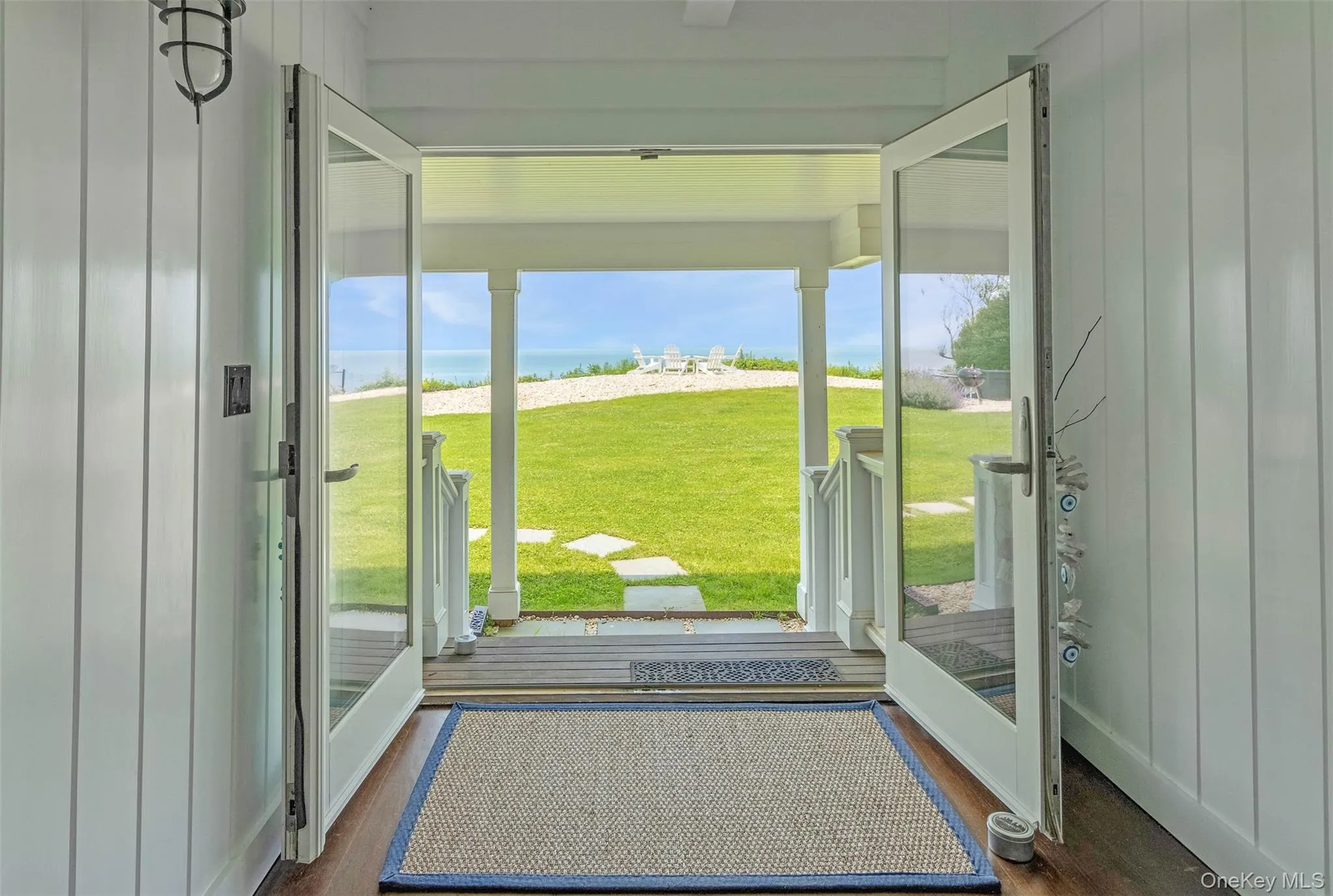 Doorway to outside with dark wood finished floors, plenty of natural light, and a water view Doorway to outside with dark wood finished floors, plenty of natural light, and a water view