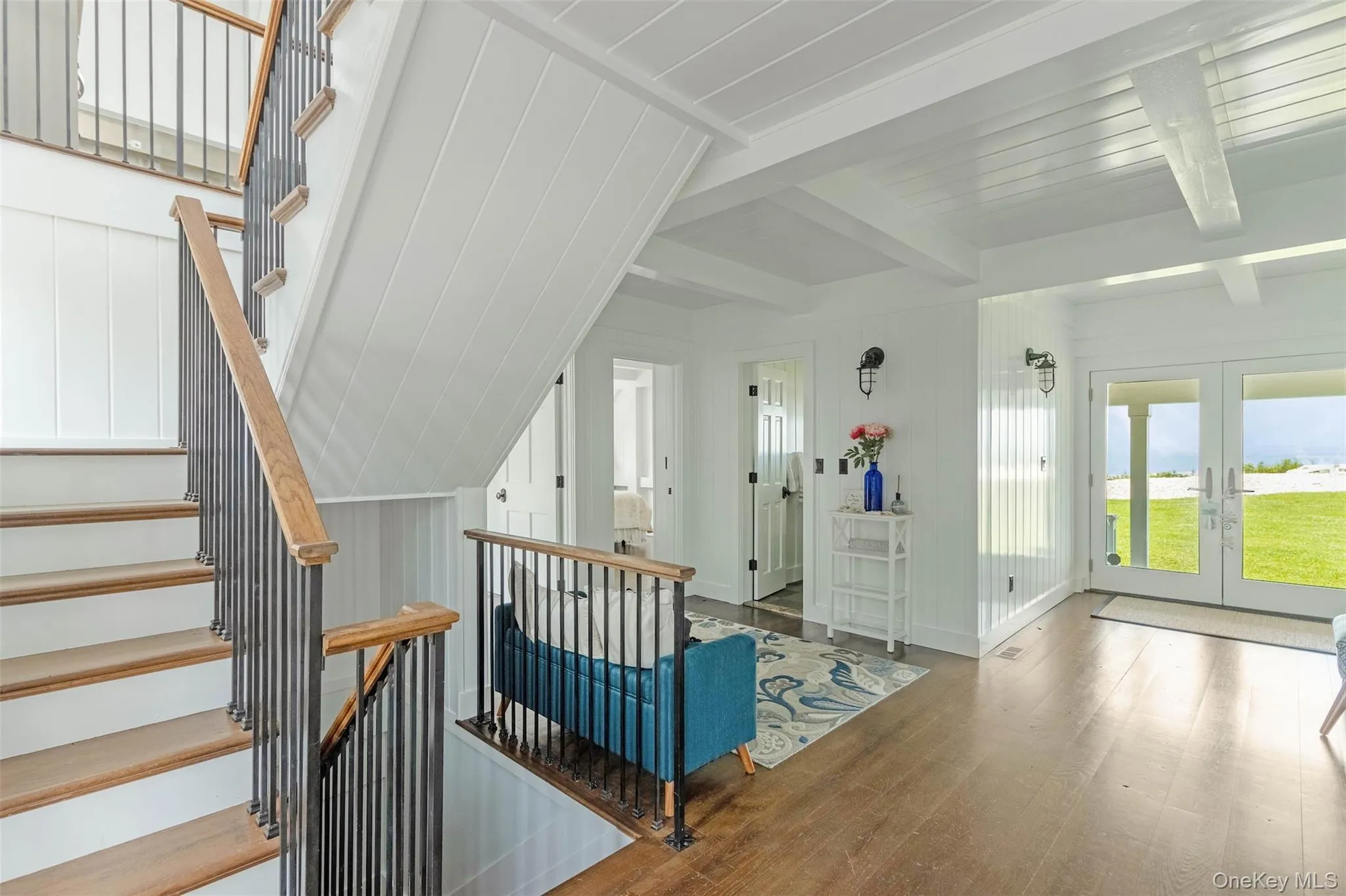 Stairs featuring wood finished floors, french doors, and beam ceiling Stairs featuring wood finished floors, french doors, and beam ceiling