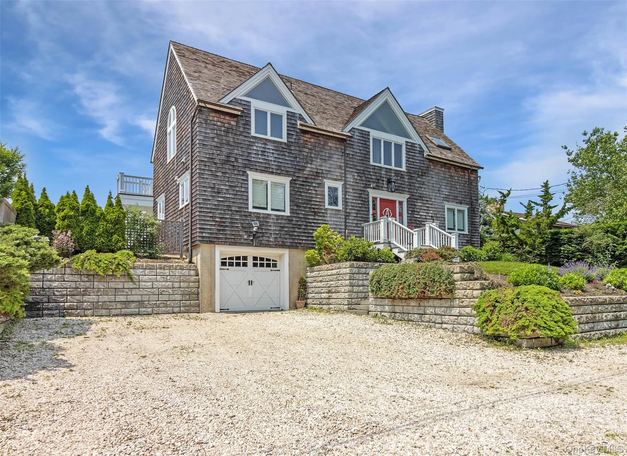 Shingle-style home with driveway, an attached garage, and a chimney Shingle-style home with driveway, an attached garage, and a chimney