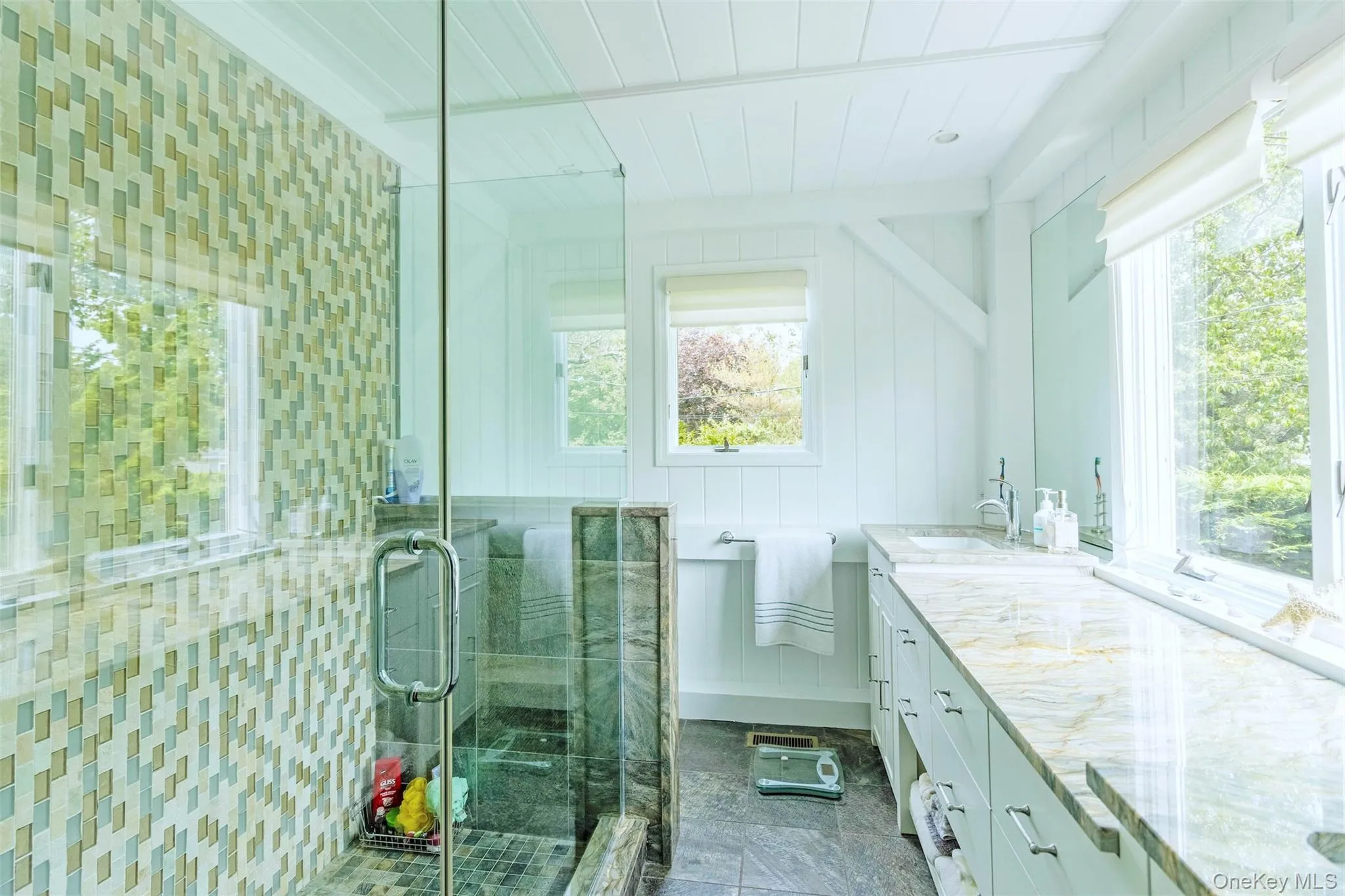 Bathroom with vanity, plenty of natural light, and a shower stall Bathroom with vanity, plenty of natural light, and a shower stall
