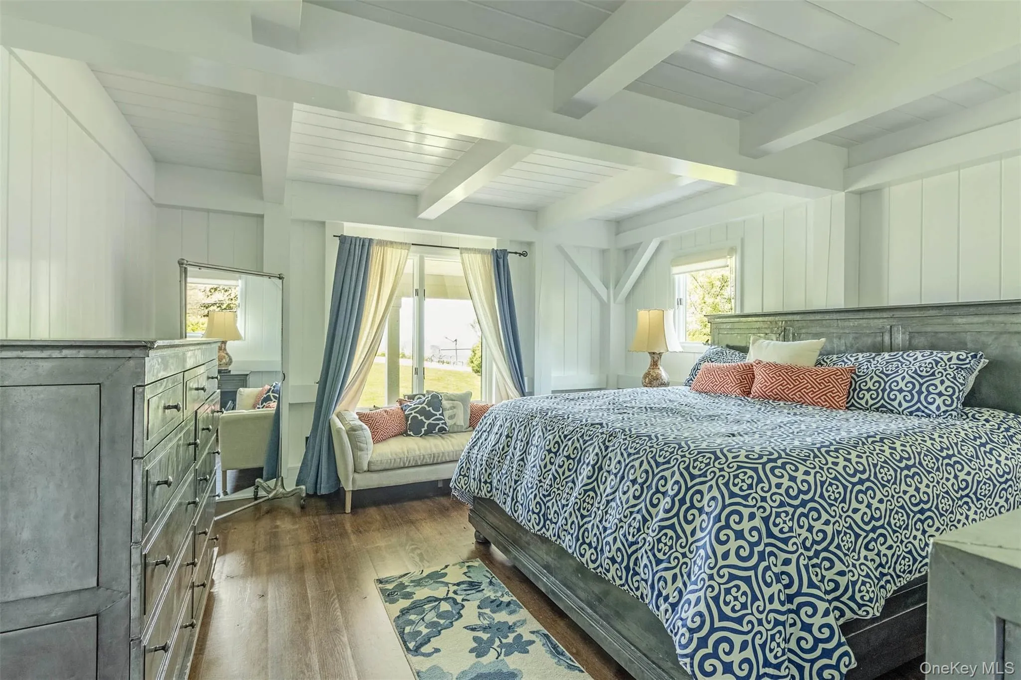 Bedroom with dark wood-type flooring, multiple windows, and beamed ceiling Bedroom with dark wood-type flooring, multiple windows, and beamed ceiling