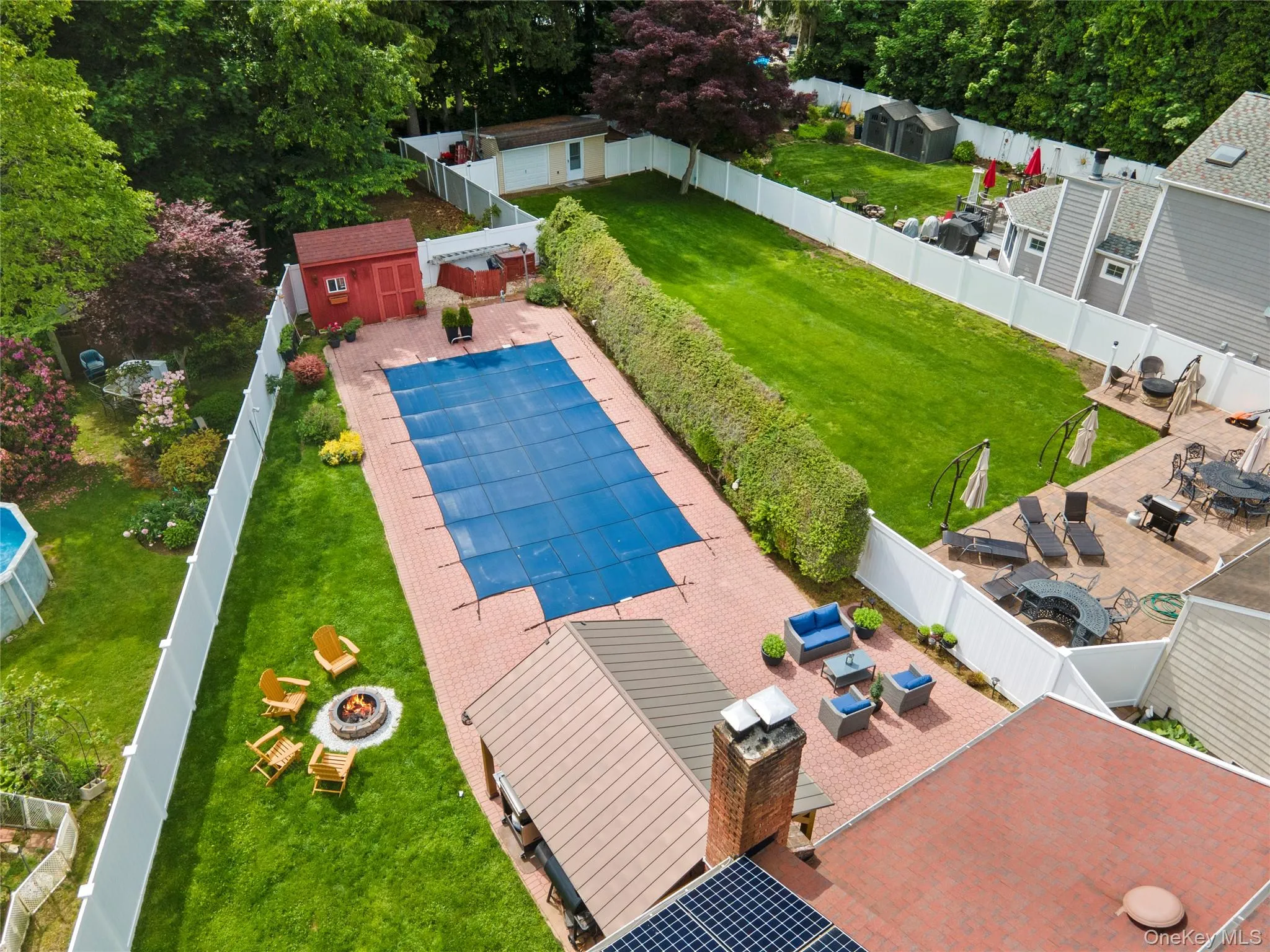 View of pool featuring a fenced backyard, a fire pit, and a storage shed View of pool featuring a fenced backyard, a fire pit, and a storage shed