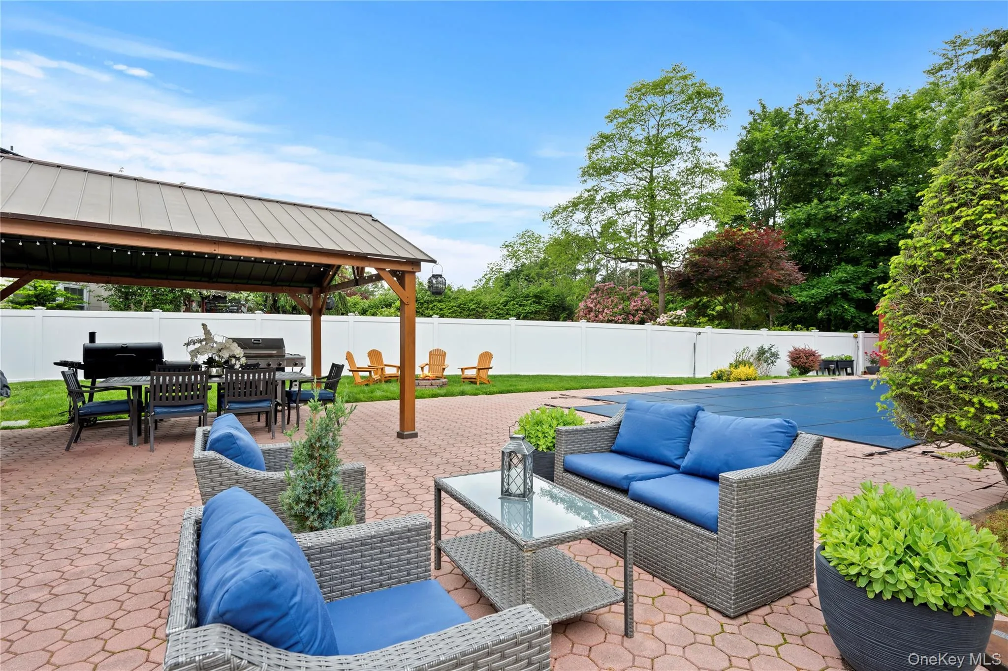 Fenced backyard featuring a gazebo, an outdoor hangout area, a patio area, outdoor dining area, and grilling area Fenced backyard featuring a gazebo, an outdoor hangout area, a patio area, outdoor dining area, and grilling area
