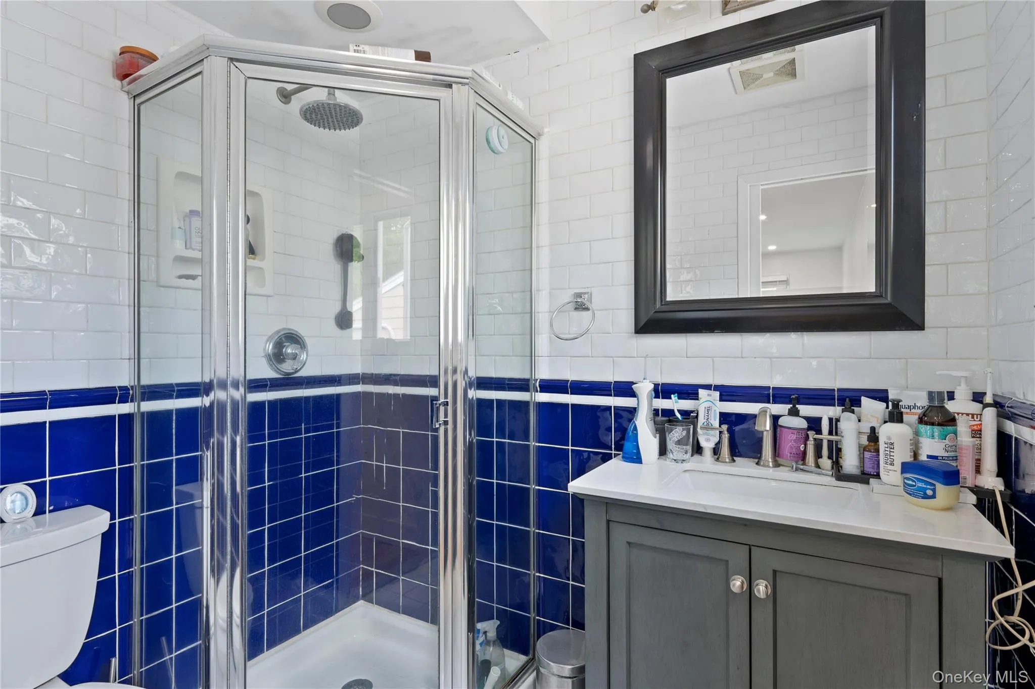 Bathroom with tile walls, vanity, and a stall shower Bathroom with tile walls, vanity, and a stall shower