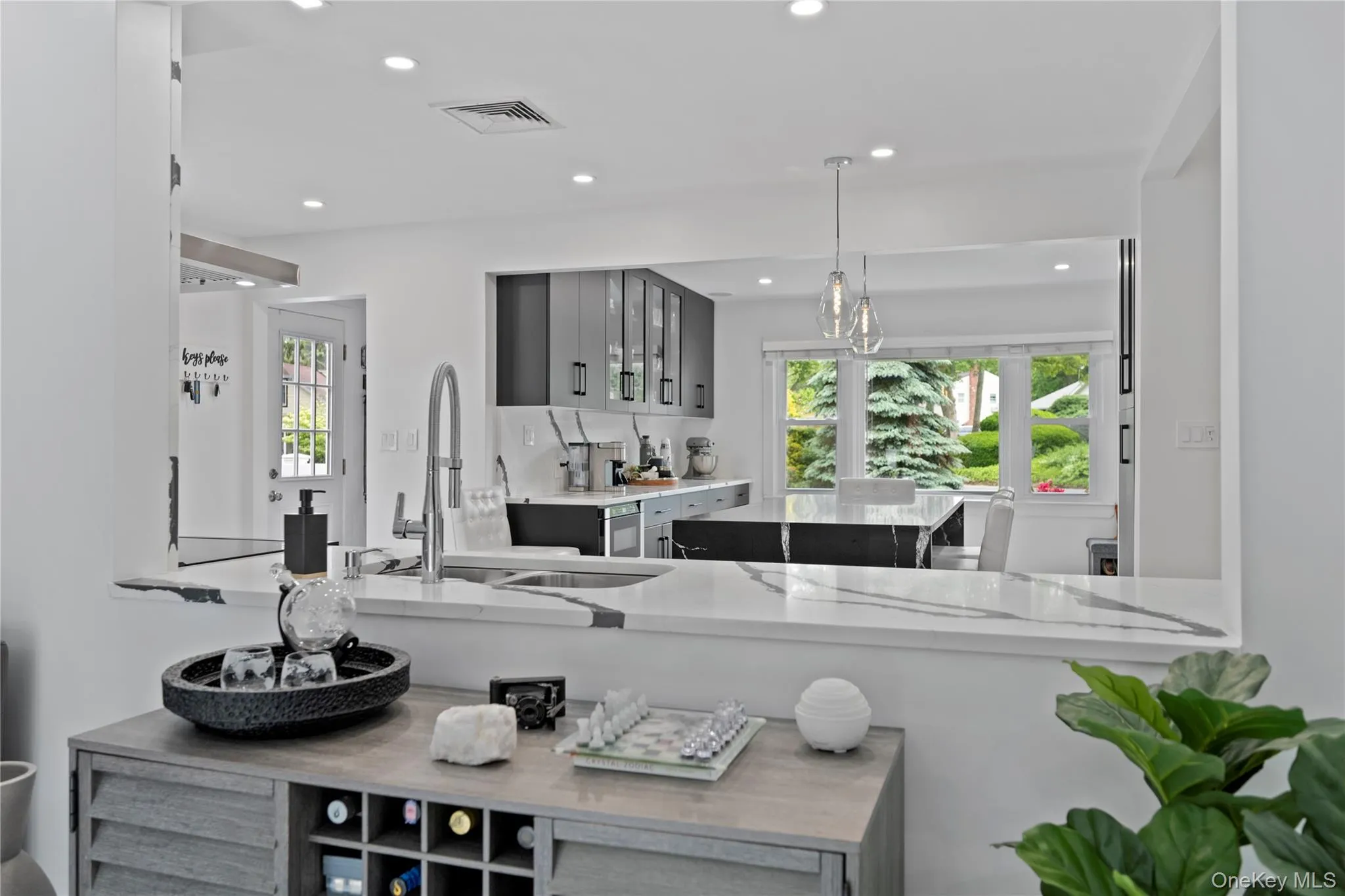Kitchen featuring gray cabinetry, recessed lighting, pendant lighting, and glass insert cabinets Kitchen featuring gray cabinetry, recessed lighting, pendant lighting, and glass insert cabinets