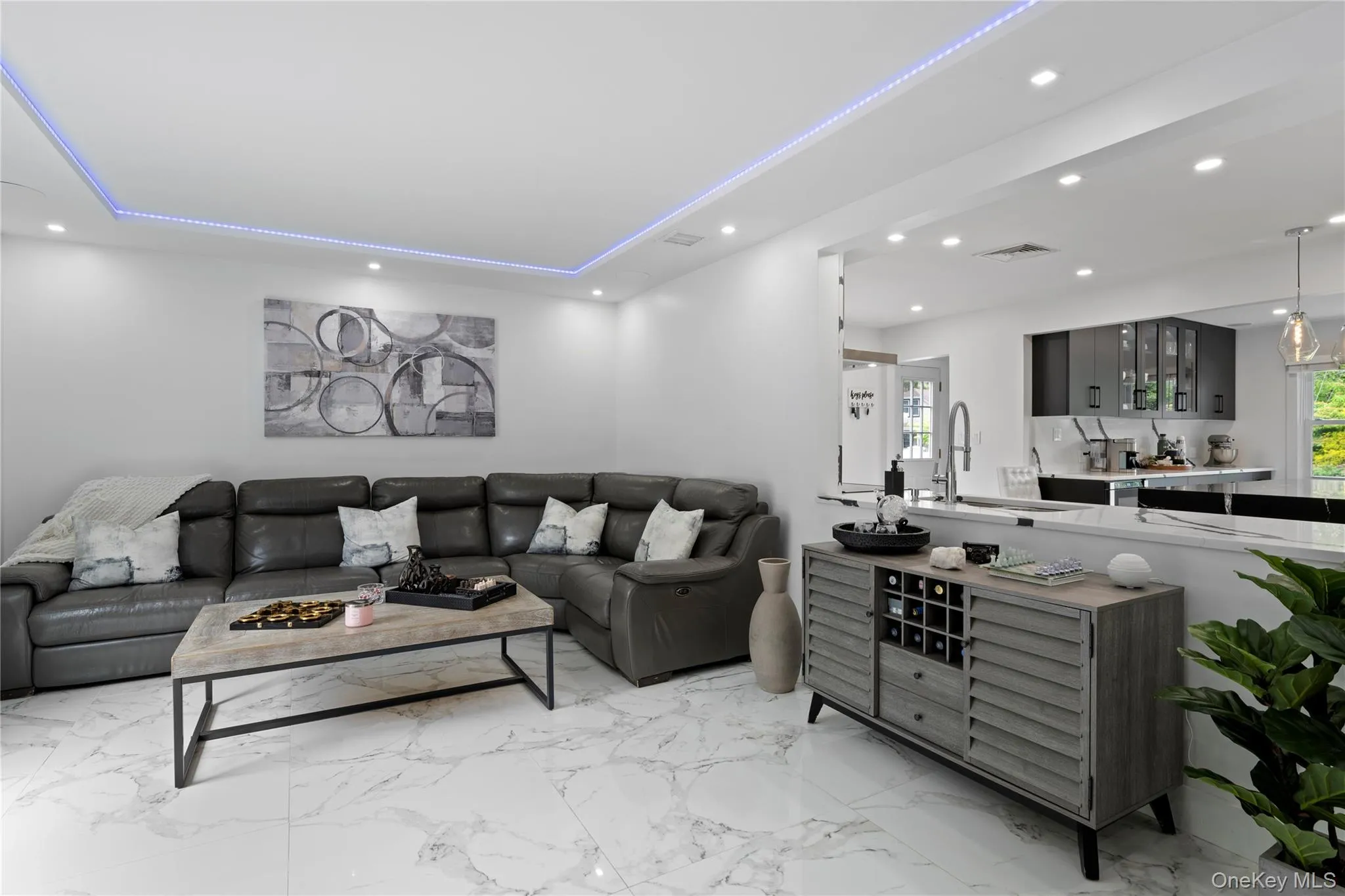 Living area with recessed lighting, light marble finish floors, and a tray ceiling Living area with recessed lighting, light marble finish floors, and a tray ceiling