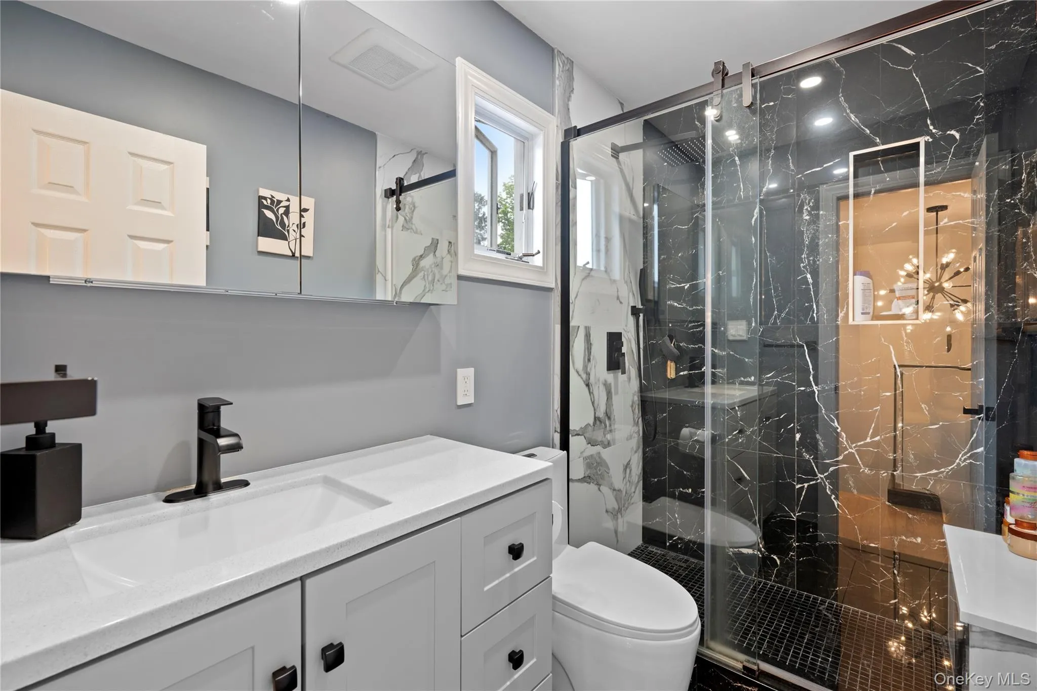 Full bath featuring vanity and a marble finish shower Full bath featuring vanity and a marble finish shower