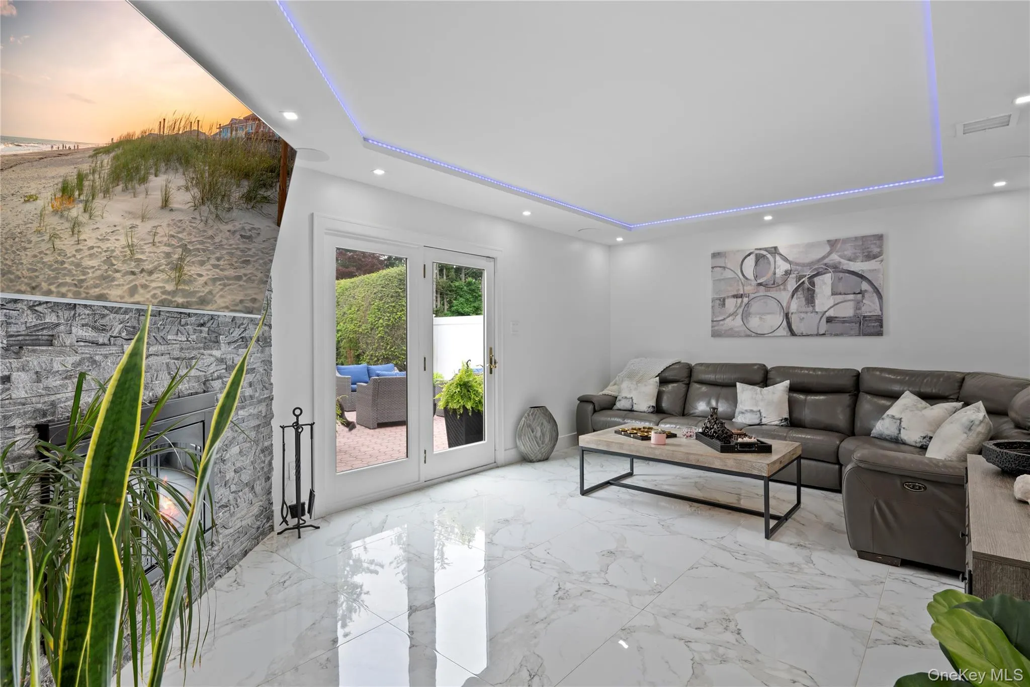 Living room with a tray ceiling, recessed lighting, a glass covered fireplace, and marble finish floors Living room with a tray ceiling, recessed lighting, a glass covered fireplace, and marble finish floors