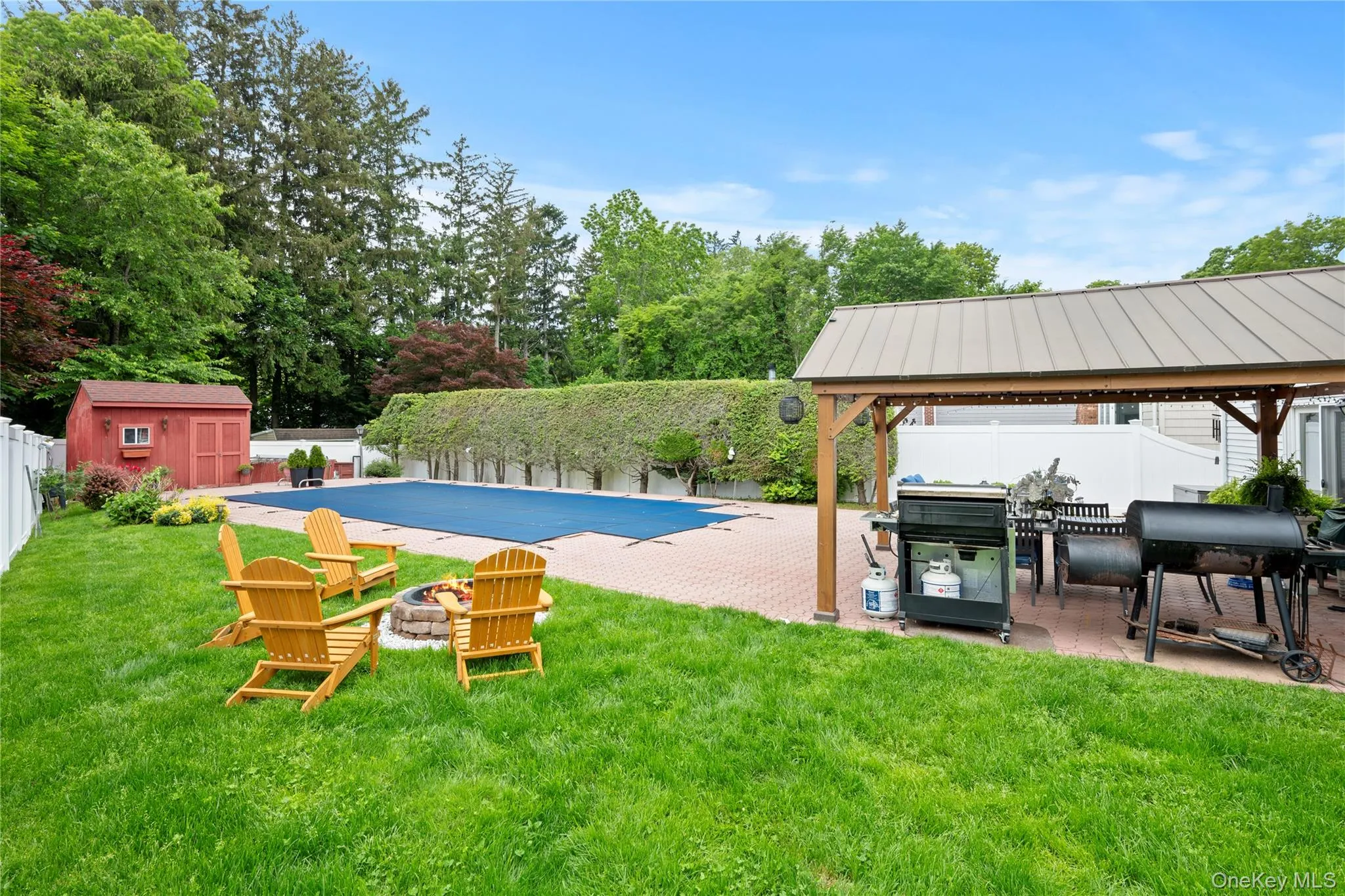 Fenced backyard featuring a gazebo, an outdoor fire pit, a patio area, and a shed Fenced backyard featuring a gazebo, an outdoor fire pit, a patio area, and a shed