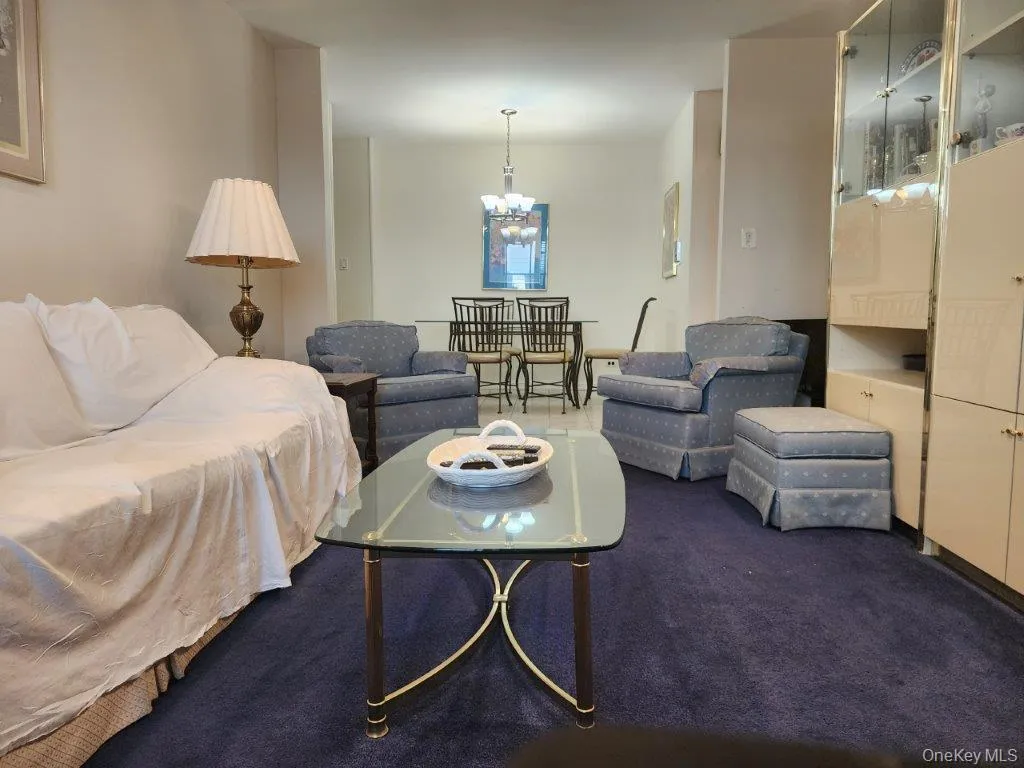 Living area with carpet floors and a chandelier Living area with carpet floors and a chandelier