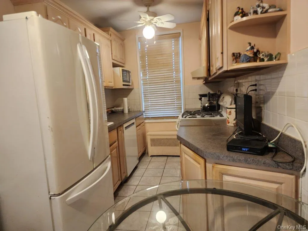Kitchen with white appliances, tasteful backsplash, and dark countertops Kitchen with white appliances, tasteful backsplash, and dark countertops