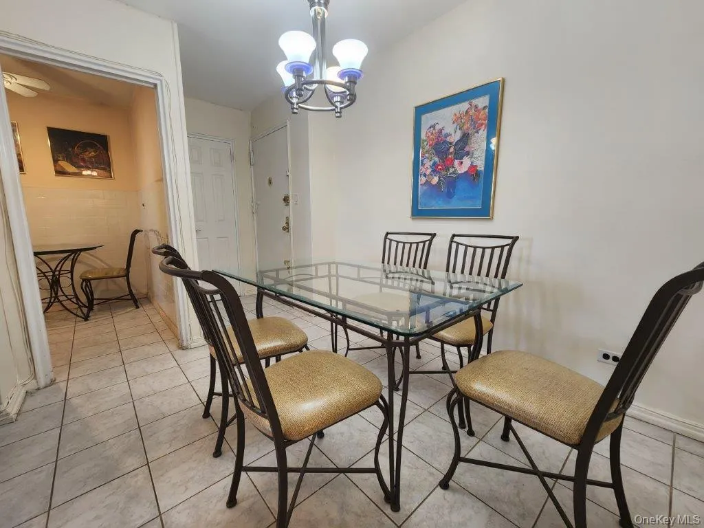 Dining area featuring light tile patterned floors and a chandelier Dining area featuring light tile patterned floors and a chandelier